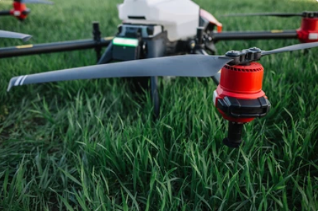 Drone positioned in a lush green field ready for fertilizer application