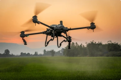 Agricultural drone flying over a field at sunset